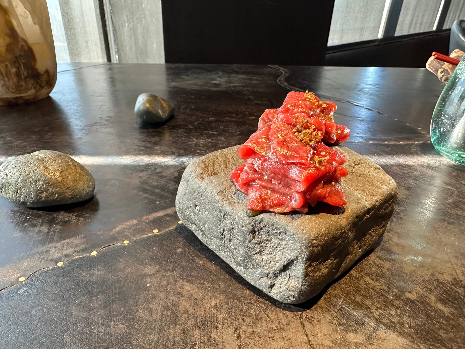 A delicate plated beef course served on stone at a fine-dining restaurant